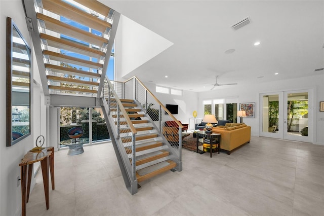 stairway featuring french doors, ceiling fan, and a healthy amount of sunlight