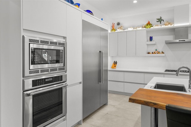 kitchen featuring built in appliances, open shelves, light countertops, and white cabinets