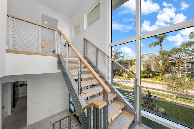 stairs featuring concrete floors and a towering ceiling