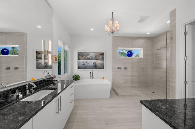 bathroom featuring vanity, independent shower and bath, and a chandelier