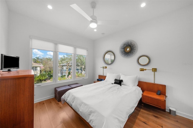 bedroom featuring hardwood / wood-style flooring, a skylight, and ceiling fan