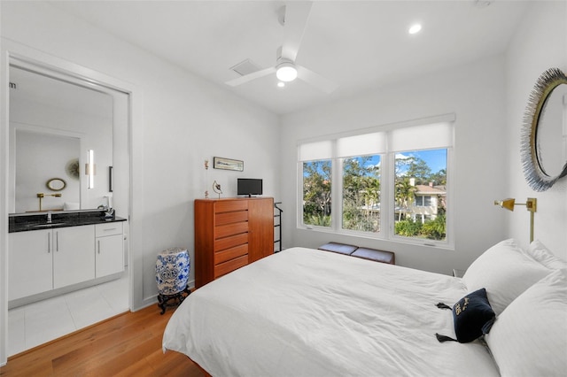 bedroom with a ceiling fan, light wood-type flooring, connected bathroom, and recessed lighting