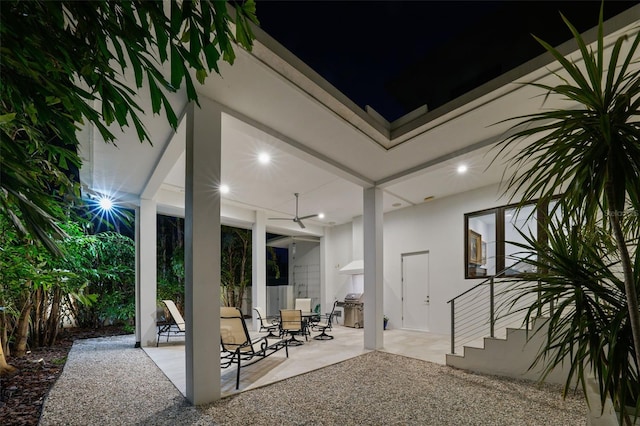 patio at twilight featuring grilling area and a ceiling fan