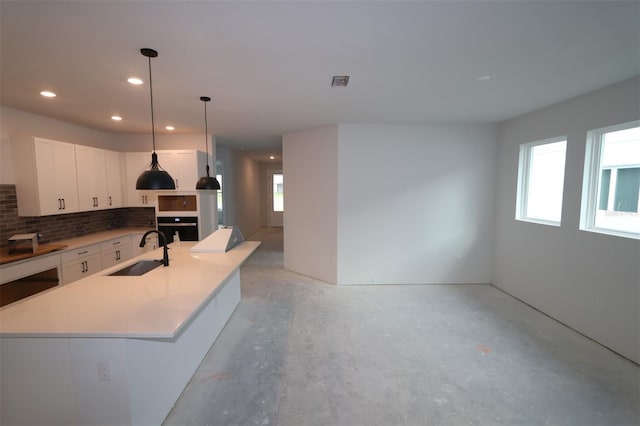 kitchen with visible vents, a sink, backsplash, white cabinetry, and wall oven