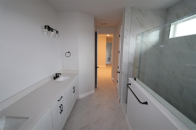 bathroom featuring double vanity, marble finish floor, a marble finish shower, and a sink