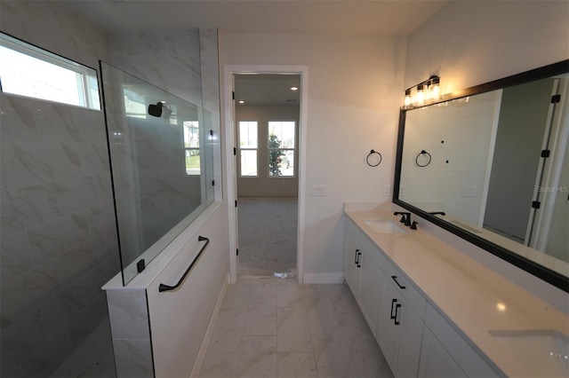 bathroom featuring double vanity, a sink, a walk in shower, baseboards, and marble finish floor