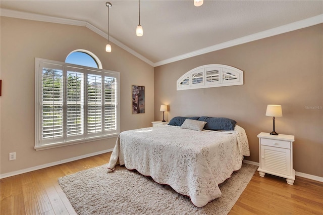 bedroom featuring hardwood / wood-style floors, lofted ceiling, and ornamental molding