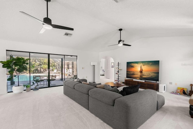 living room featuring lofted ceiling, a textured ceiling, light colored carpet, and ceiling fan