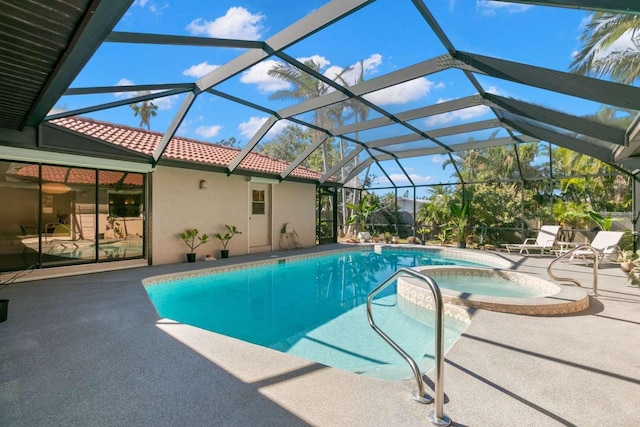 view of swimming pool featuring a patio, glass enclosure, and an in ground hot tub