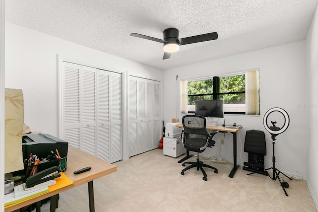 office with ceiling fan, light carpet, and a textured ceiling