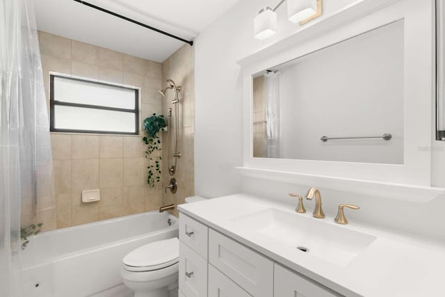 full bathroom featuring tiled shower / bath, vanity, and toilet