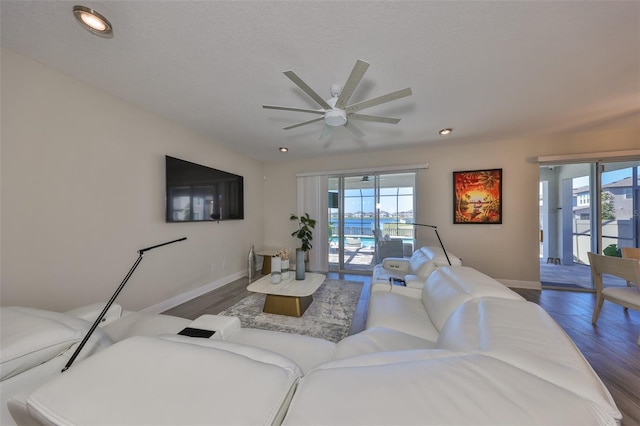 living room featuring dark hardwood / wood-style flooring, plenty of natural light, and ceiling fan