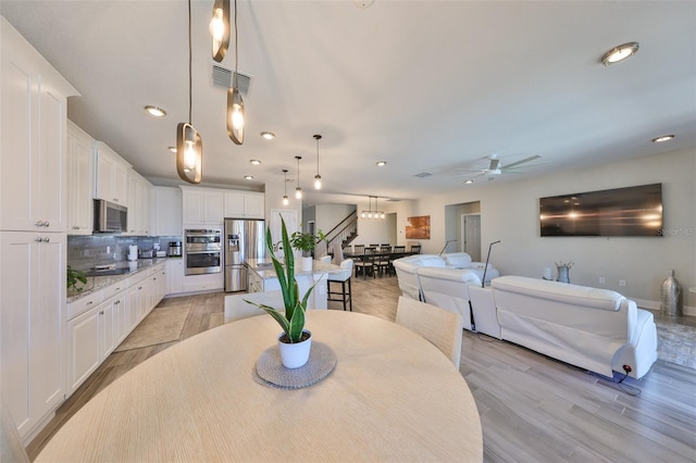 dining area with light hardwood / wood-style flooring and ceiling fan