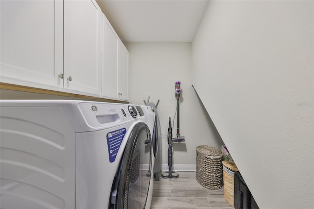 laundry room with separate washer and dryer and cabinets