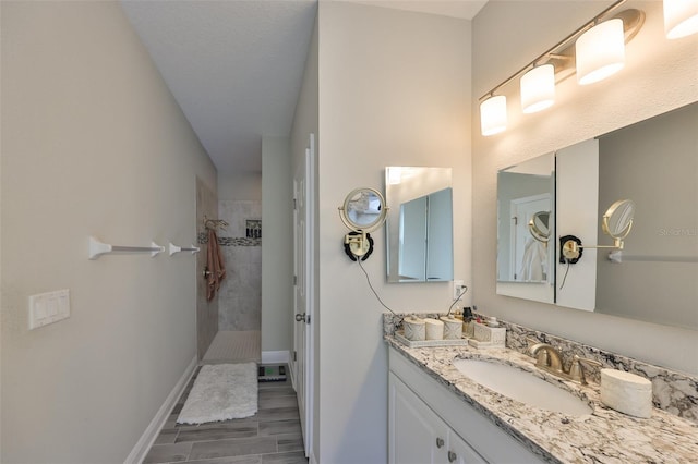 bathroom with vanity and a tile shower