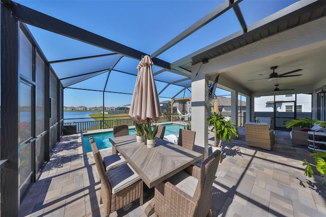 view of patio featuring a water view, ceiling fan, and a lanai