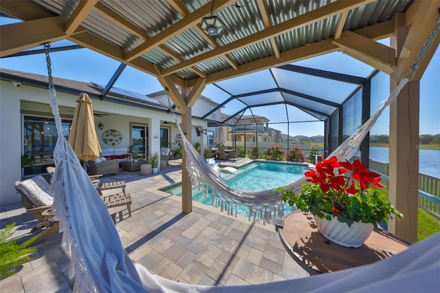 view of swimming pool featuring a patio area, a water view, glass enclosure, ceiling fan, and an outdoor living space