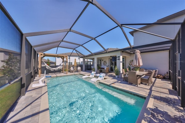 view of swimming pool featuring ceiling fan, glass enclosure, and a patio area