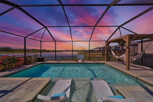 pool at dusk with a patio, a water view, a lanai, and a pool with connected hot tub