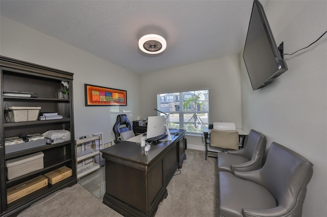 office space featuring light colored carpet, vaulted ceiling, and baseboards