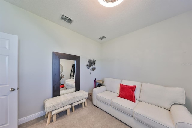 living room featuring carpet, visible vents, a textured ceiling, and baseboards