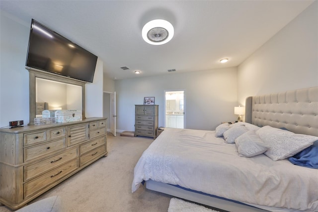 bedroom featuring baseboards, visible vents, ensuite bathroom, and light colored carpet