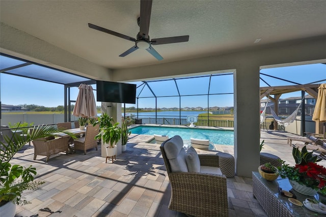 view of swimming pool with a patio area, ceiling fan, glass enclosure, and a fenced in pool