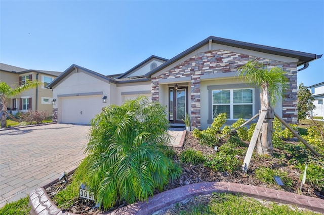 view of front of house with a garage, decorative driveway, and stucco siding