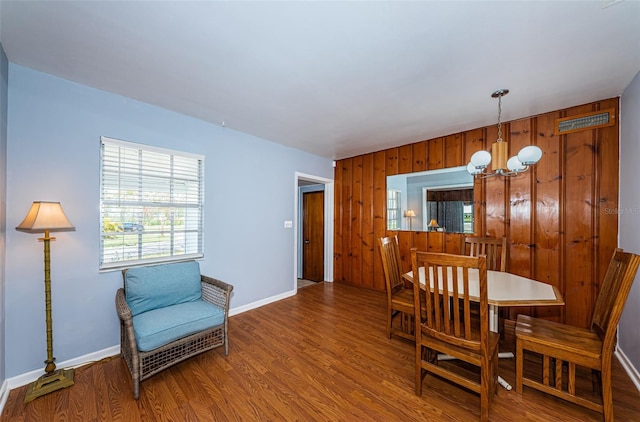 dining space featuring hardwood / wood-style floors and an inviting chandelier