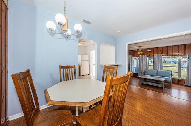 dining room featuring dark wood-type flooring and ceiling fan with notable chandelier