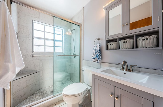 bathroom with vanity, a shower with door, and toilet