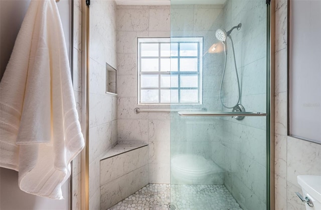 bathroom with a shower with shower door and toilet