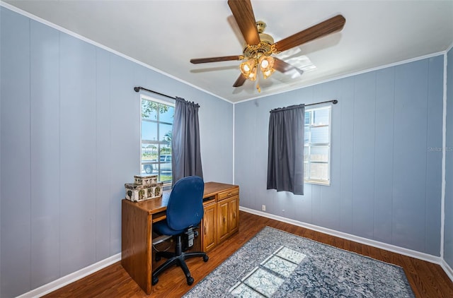 home office with dark wood-type flooring, ceiling fan, and crown molding