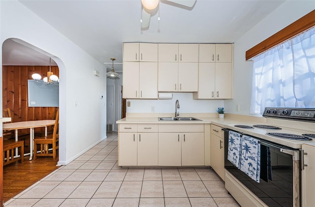 kitchen featuring sink, light tile patterned floors, pendant lighting, ceiling fan with notable chandelier, and white range with electric stovetop