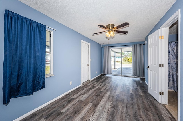 spare room featuring ceiling fan, dark hardwood / wood-style floors, and a textured ceiling