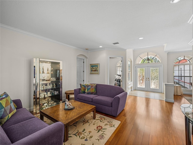 living room featuring ornamental molding, light hardwood / wood-style floors, and french doors