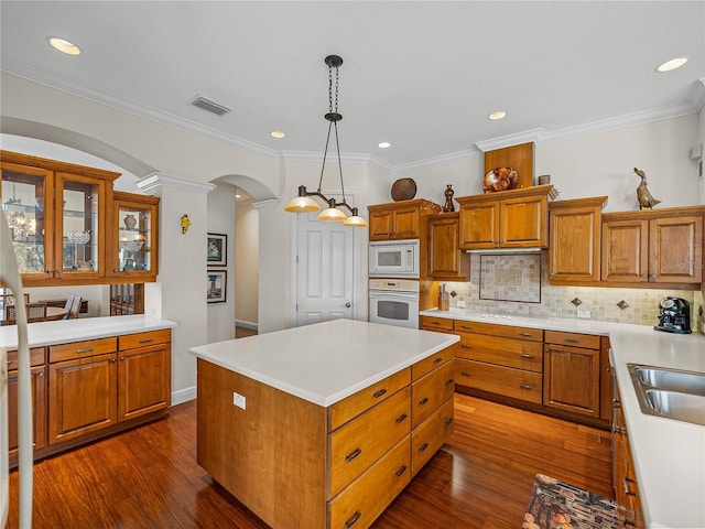 kitchen featuring white appliances, backsplash, a center island, dark hardwood / wood-style flooring, and decorative light fixtures