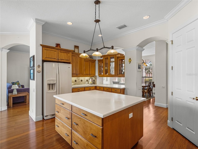 kitchen featuring a kitchen island, dark hardwood / wood-style floors, tasteful backsplash, hanging light fixtures, and white fridge with ice dispenser