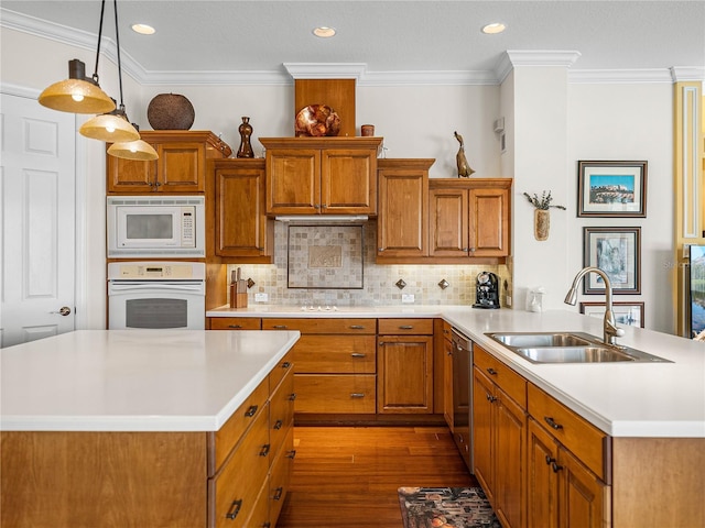 kitchen featuring decorative light fixtures, wood-type flooring, sink, backsplash, and white appliances