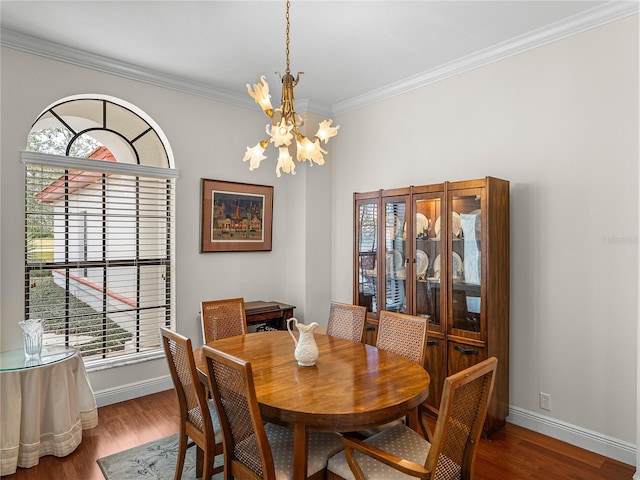 dining space with hardwood / wood-style floors, crown molding, and a chandelier