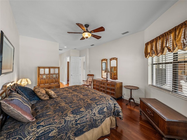 bedroom with dark hardwood / wood-style floors and ceiling fan