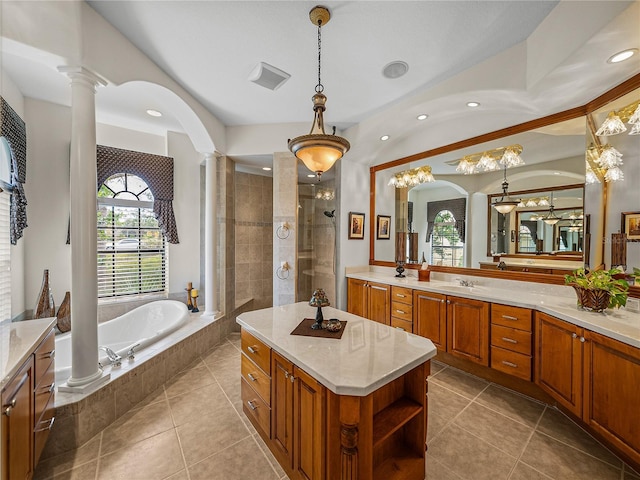 bathroom featuring tile patterned floors, vanity, shower with separate bathtub, and ornate columns