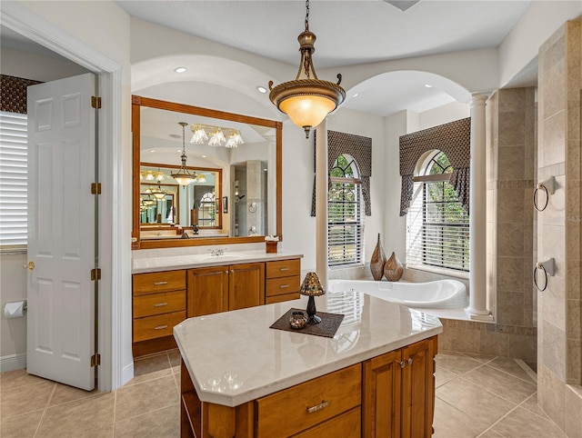 bathroom featuring ornate columns, vanity, tiled shower, and tile patterned floors