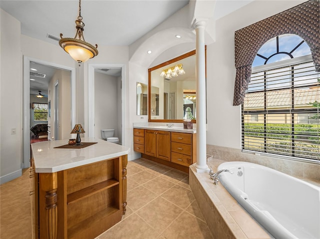 bathroom with tile patterned floors, toilet, ornate columns, vanity, and a healthy amount of sunlight