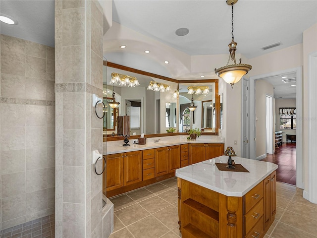 bathroom featuring tile patterned flooring, a shower, and vanity