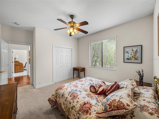 bedroom featuring light carpet, a closet, and ceiling fan