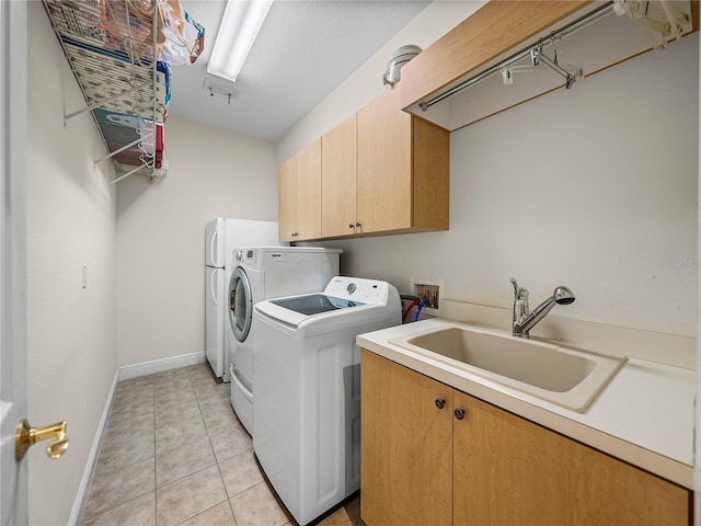 laundry area with cabinets, separate washer and dryer, sink, and light tile patterned floors