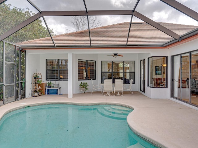 view of swimming pool featuring ceiling fan, a lanai, and a patio