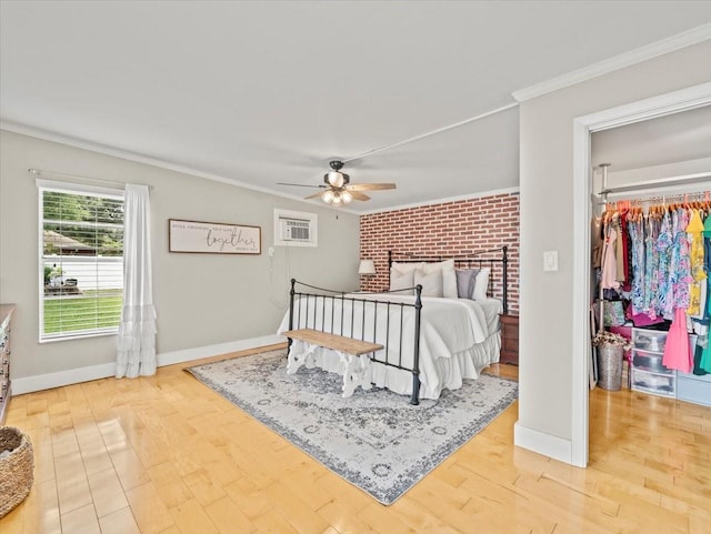 bedroom with hardwood / wood-style flooring, ceiling fan, ornamental molding, and brick wall