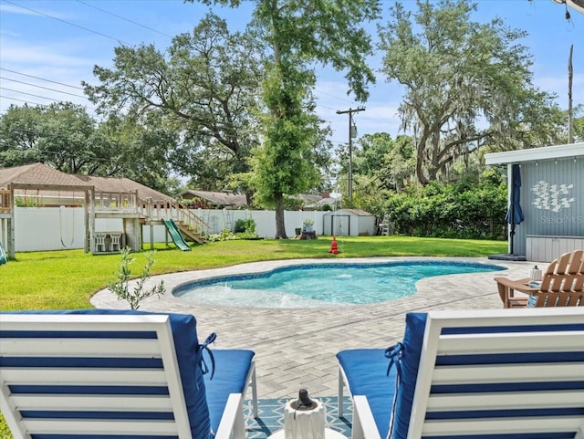 view of swimming pool with a shed, a lawn, a playground, and a patio area